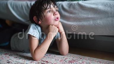 一个头发湿漉漉的小学生躺在他房间的地板上，望着窗外